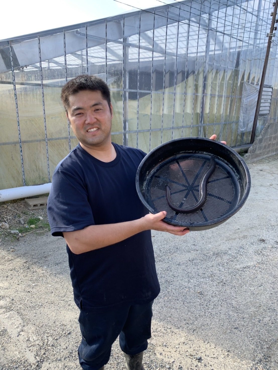 道具を持つスタッフ(左)とハウスの池と水車(右)